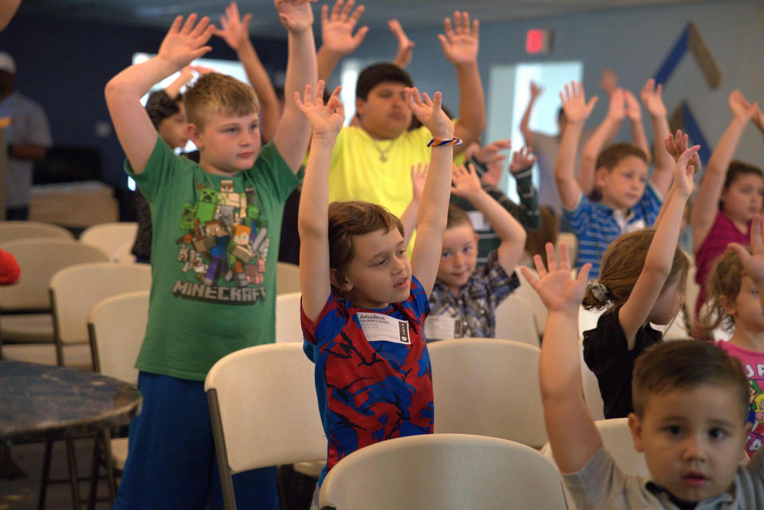 Children raising their hands during Bethany Kids
