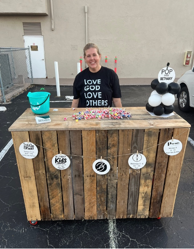 Volunteers greeting children and handing out candy at a community event