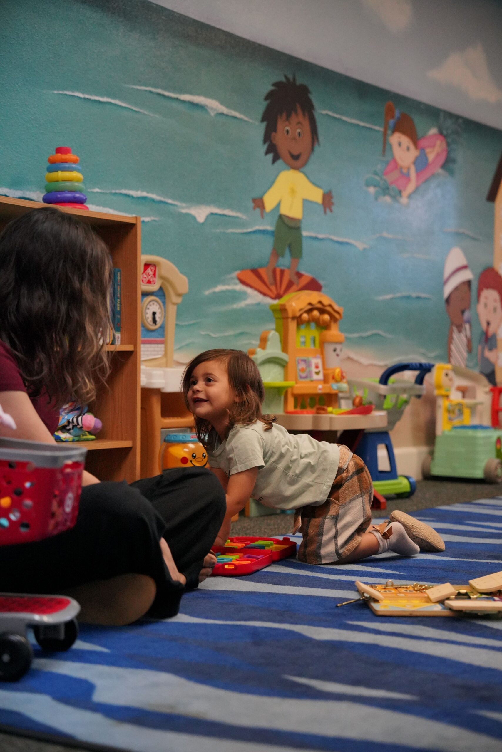 Young child smiling and playing in the Little Ones ministry room at Bethany Church