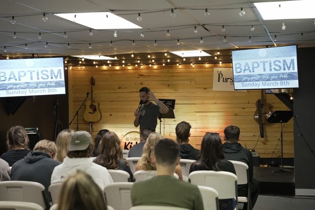 Young adults worshiping with hands raised during a Pursuit worship night