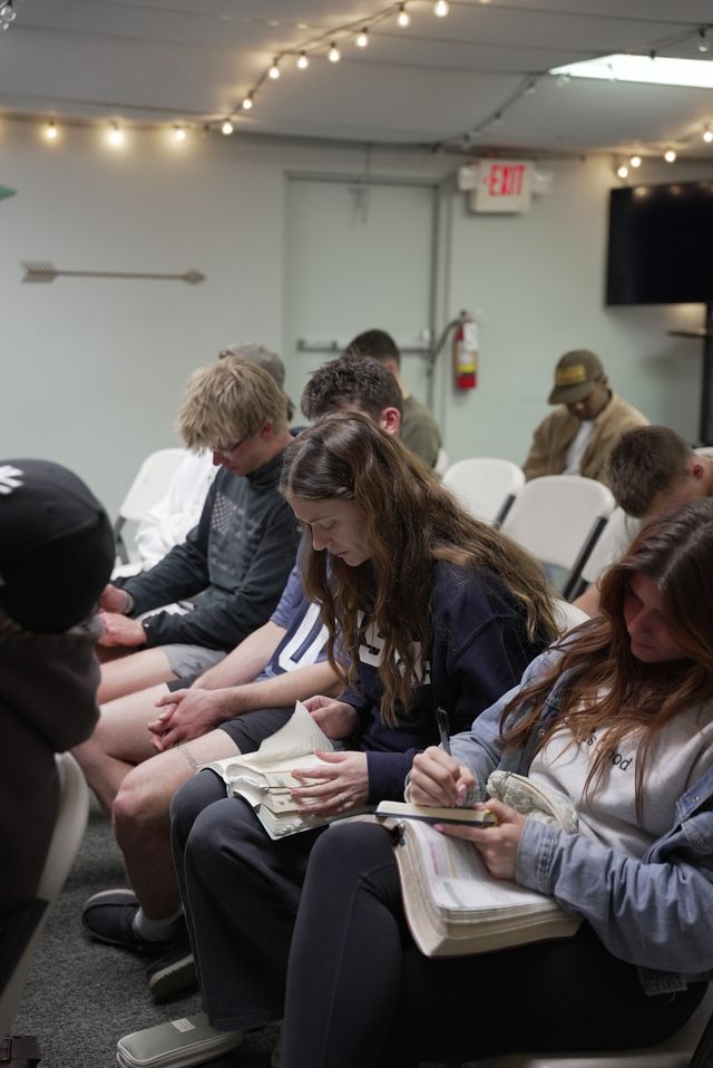 Young adults reading Bibles and taking notes during teaching at The Pursuit