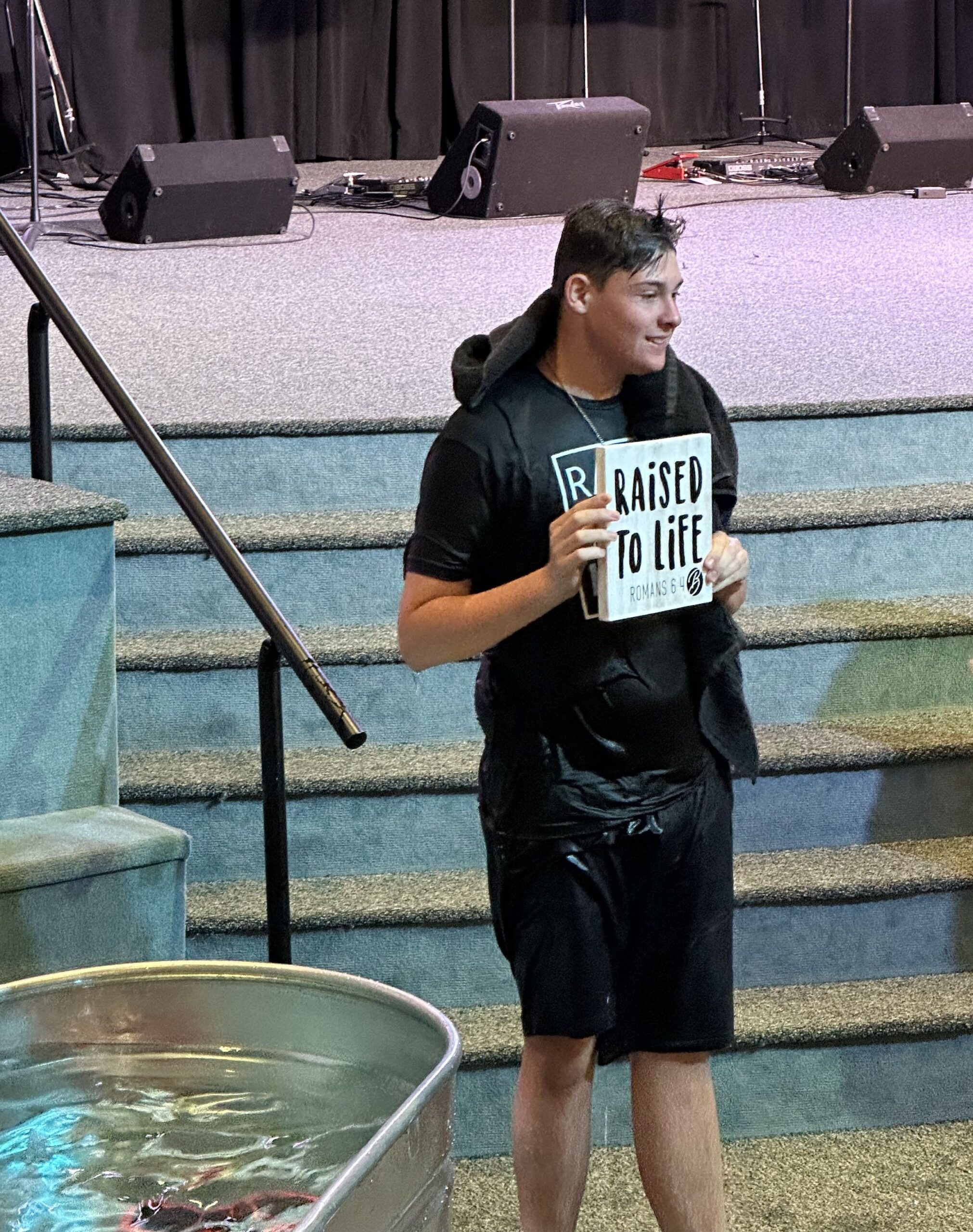 Teen holding Raised to Life sign after baptism at Bethany Church in West Melbourne Florida